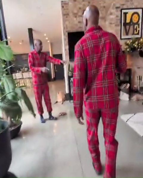 Two men in red plaid pajamas in a home.