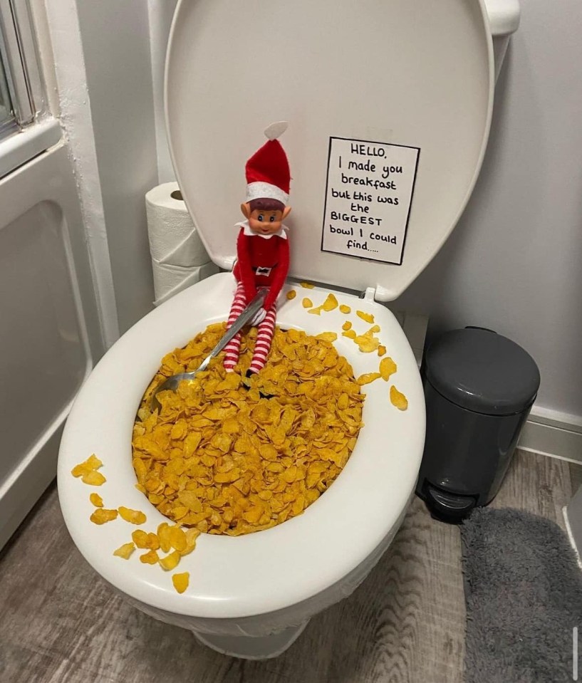 Elf on the shelf in a toilet bowl filled with cereal.