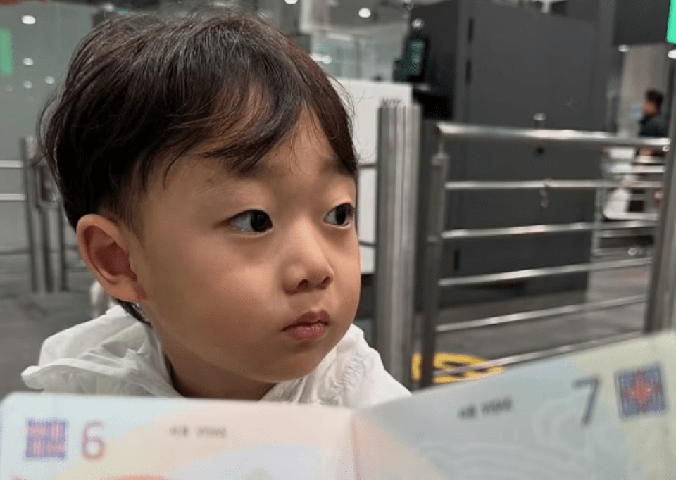 An image of the toddler waiting to use his passport for the first time as the family prepared to fly to Bangkok for Christmas