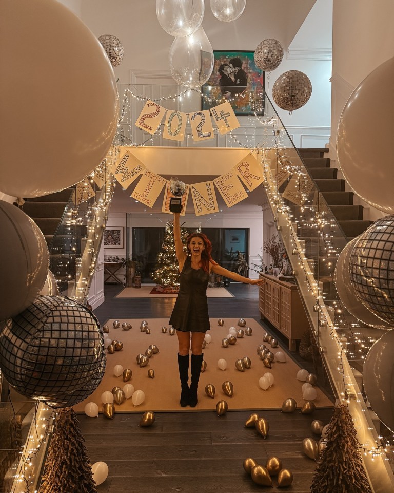 Dianne Buswell holding a trophy in a celebratory setting.