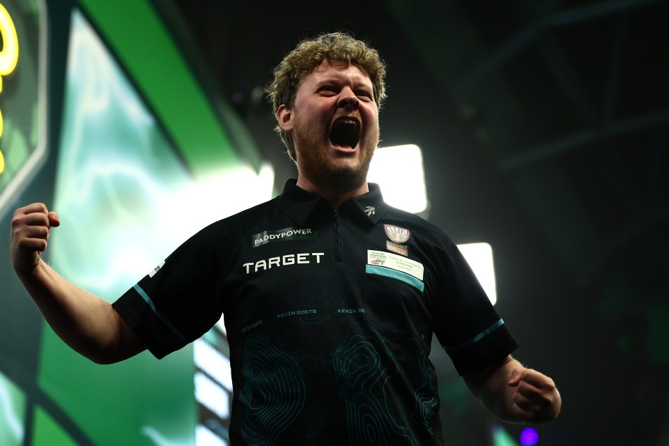 A darts player celebrates.