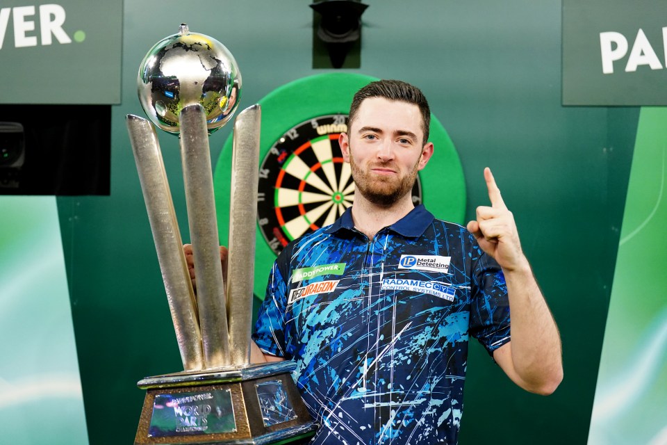 Luke Humphries holding the Paddy Power World Darts Championship trophy.