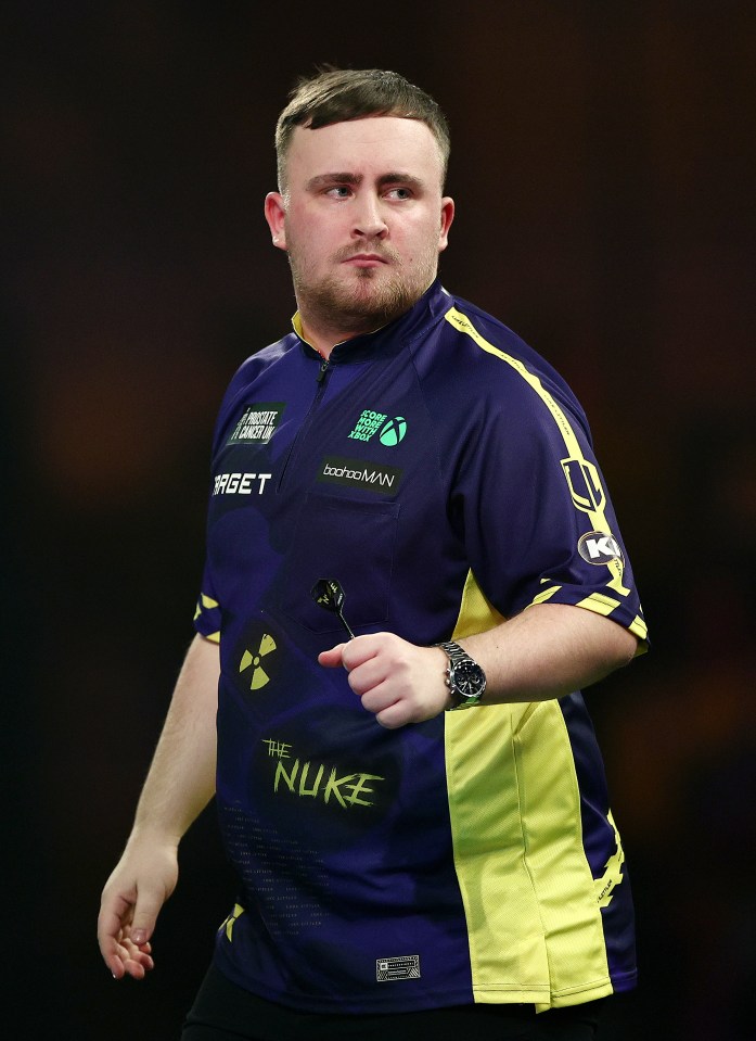 Luke Littler, a darts player, holds a dart.