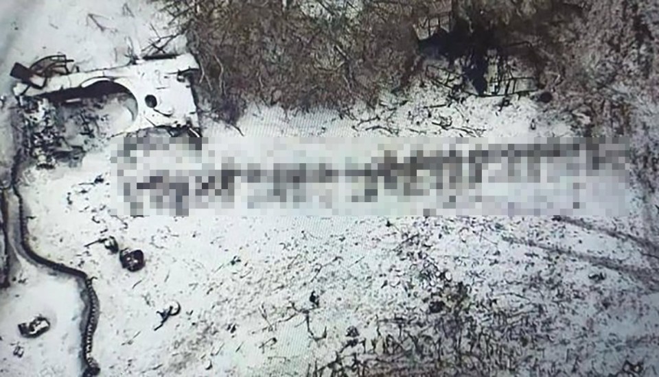 Aerial view of destroyed military vehicle and possible casualties in snowy terrain.