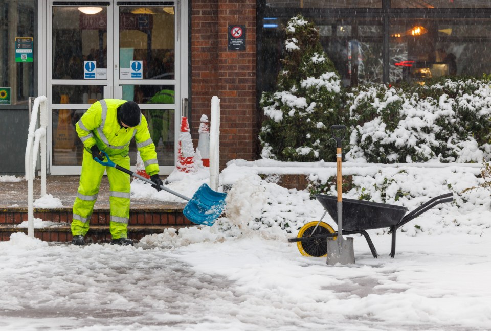 A man clears snow at the M9 motorway services near Stirling on November 23