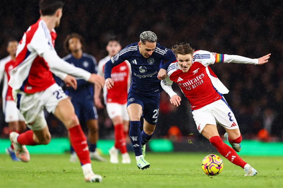 Arsenal's Odegaard under pressure from Manchester United's Antony during a Premier League match.