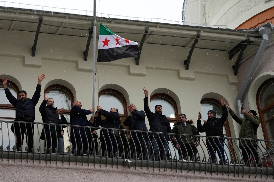 Members of the Syrian diaspora have set up a flag at the Syrian embassy in Moscow