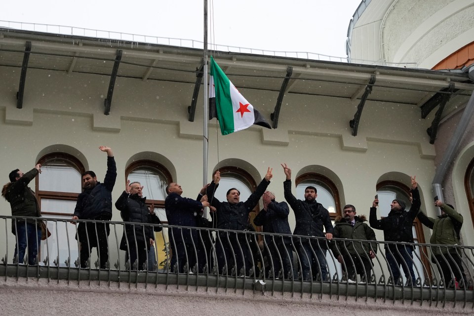 The Syrian opposition flag is raised at the Syrian embassy, in Moscow this morning