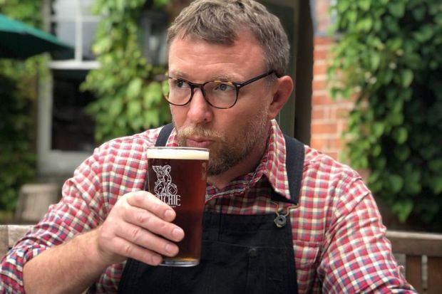 Man drinking beer outdoors.