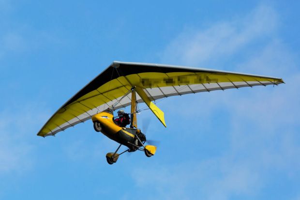 Yellow hang glider in flight.