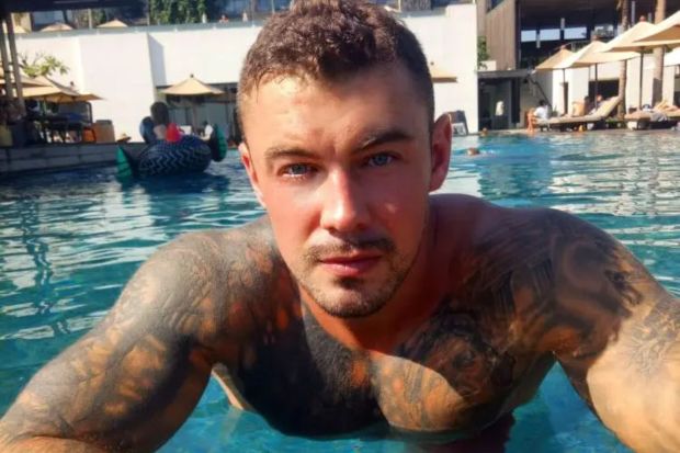 Man with tattoos in a swimming pool.