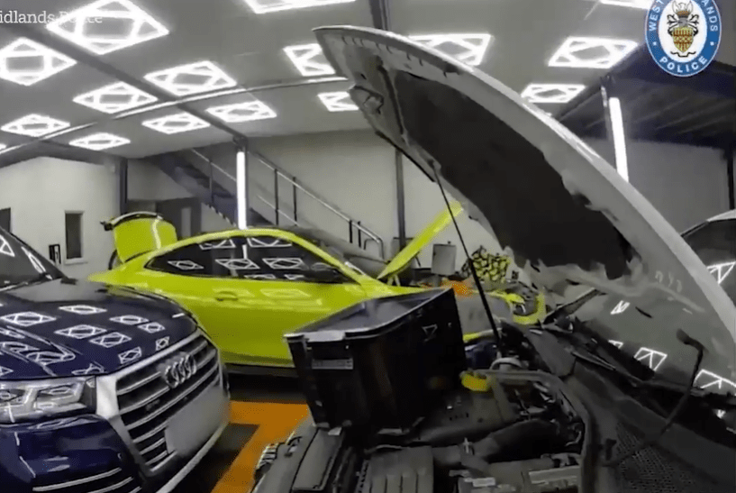 Police raid a workshop containing several stolen luxury cars.