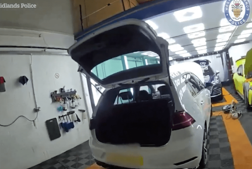 Police raid on a workshop containing stolen luxury cars.