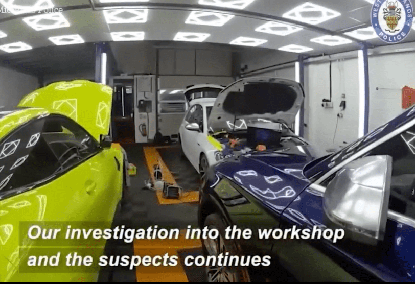 Police investigating a workshop containing stolen luxury cars.