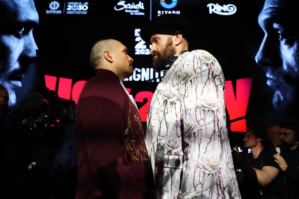 Tyson Fury and Oleksandr Usyk face off at a press conference.