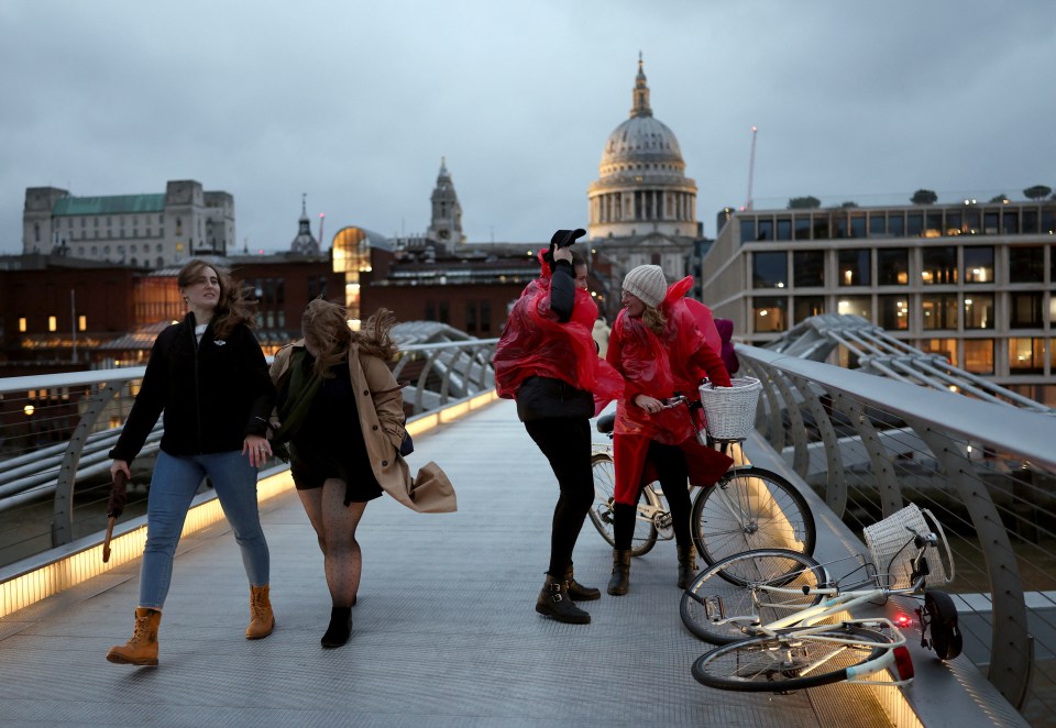 People battling against a gust of wind on Millennium Bridge in London amid Storm Darragh