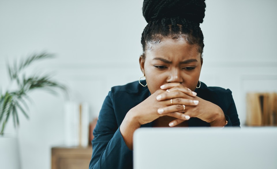 Businesswoman frowning at laptop.