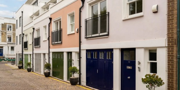 Row of colorful townhouses with garage doors.