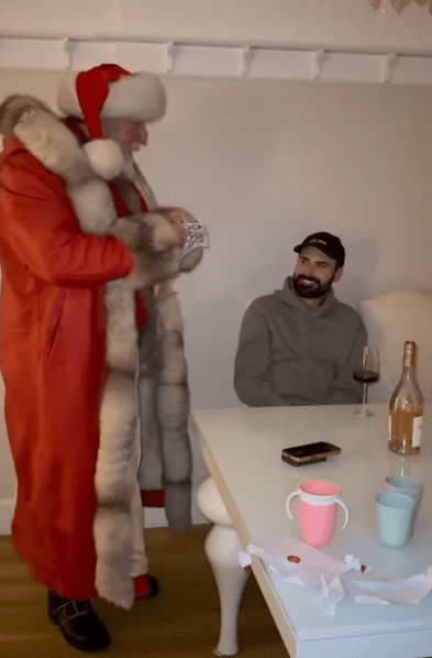 Santa Claus giving money to a man.