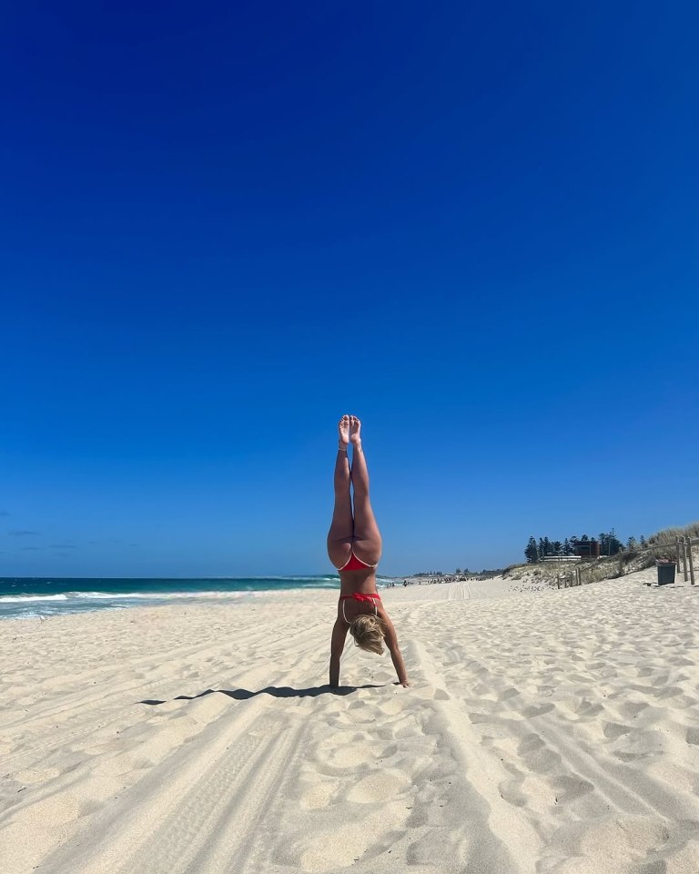 Polly, 28, performed a handstand on the beach after re-locating to Australia