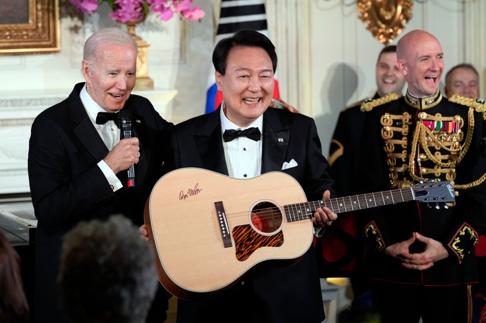 President Biden presents President Yoon Suk Yeol with a signed guitar.