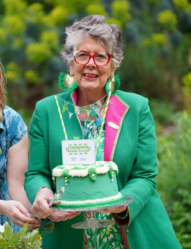 Prue Leith holding a cake at The Big Lunch event.