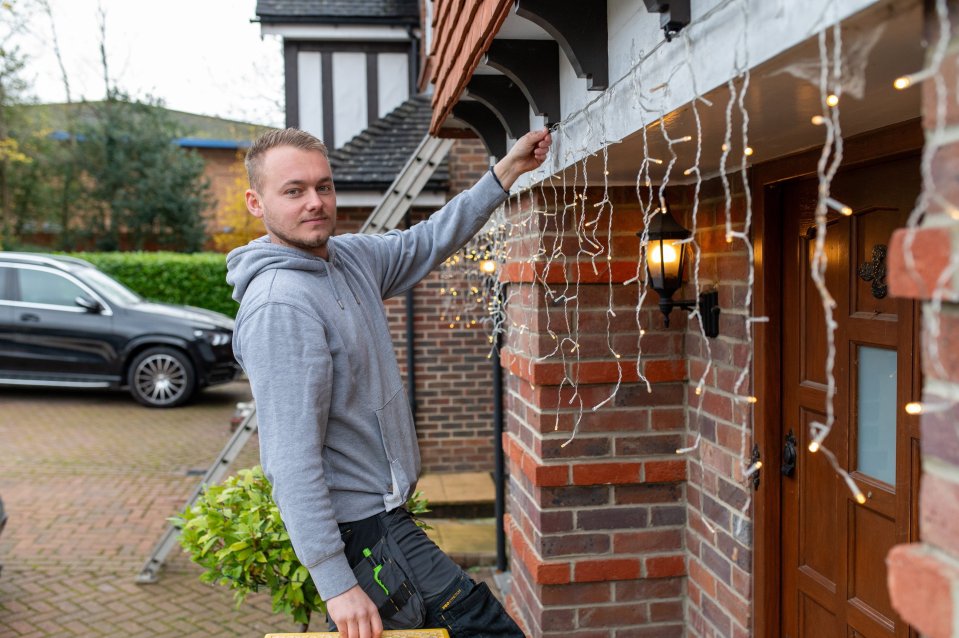 Josh at work putting lights up outside a home