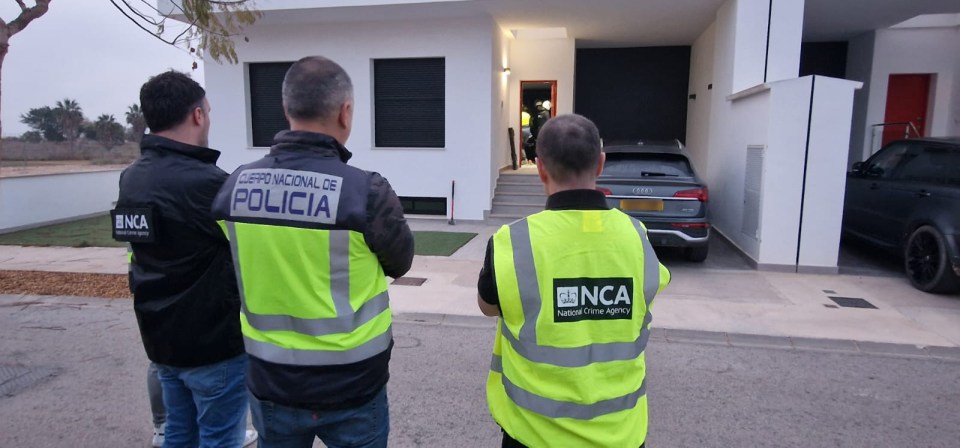 Spanish and UK law enforcement officers outside a house.