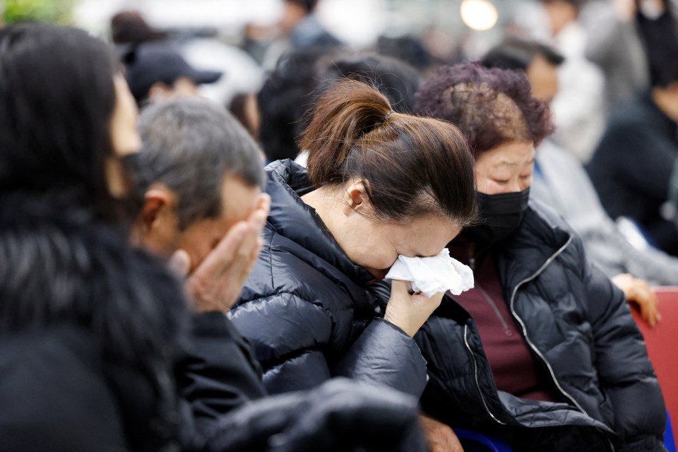 Relatives of passengers cry inside the airport as they wait for news