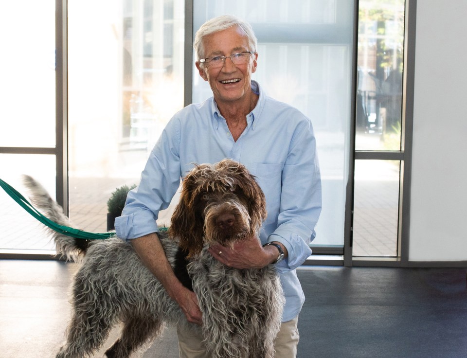 Paul O'Grady holding a dog.