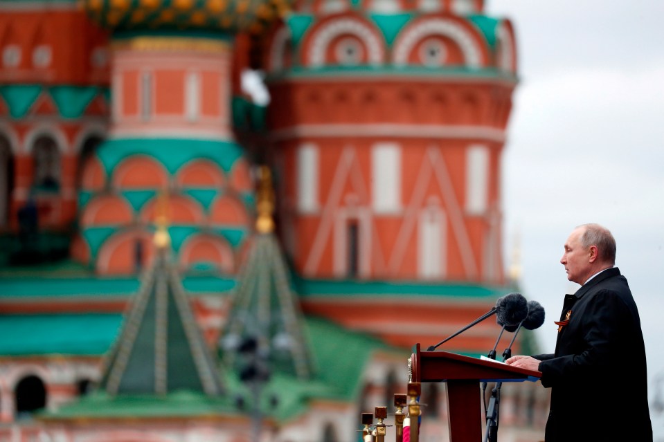 Putin speaking in front of St Basil's Cathedral during a military parade