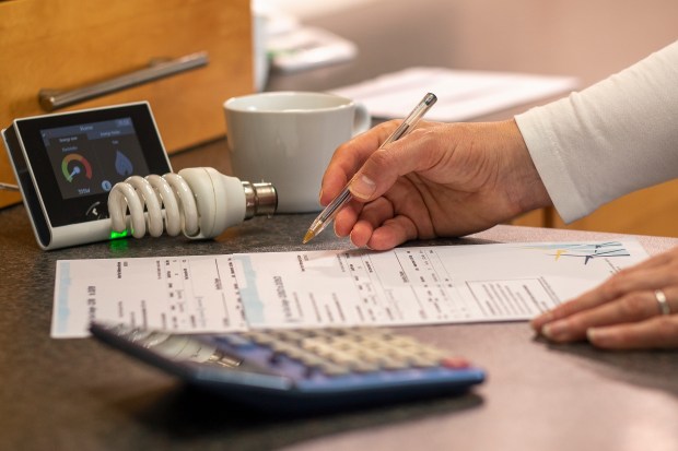 Woman reviewing an energy bill and using a calculator.