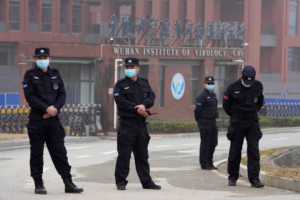 Security personnel in face masks stand outside the Wuhan Institute of Virology.