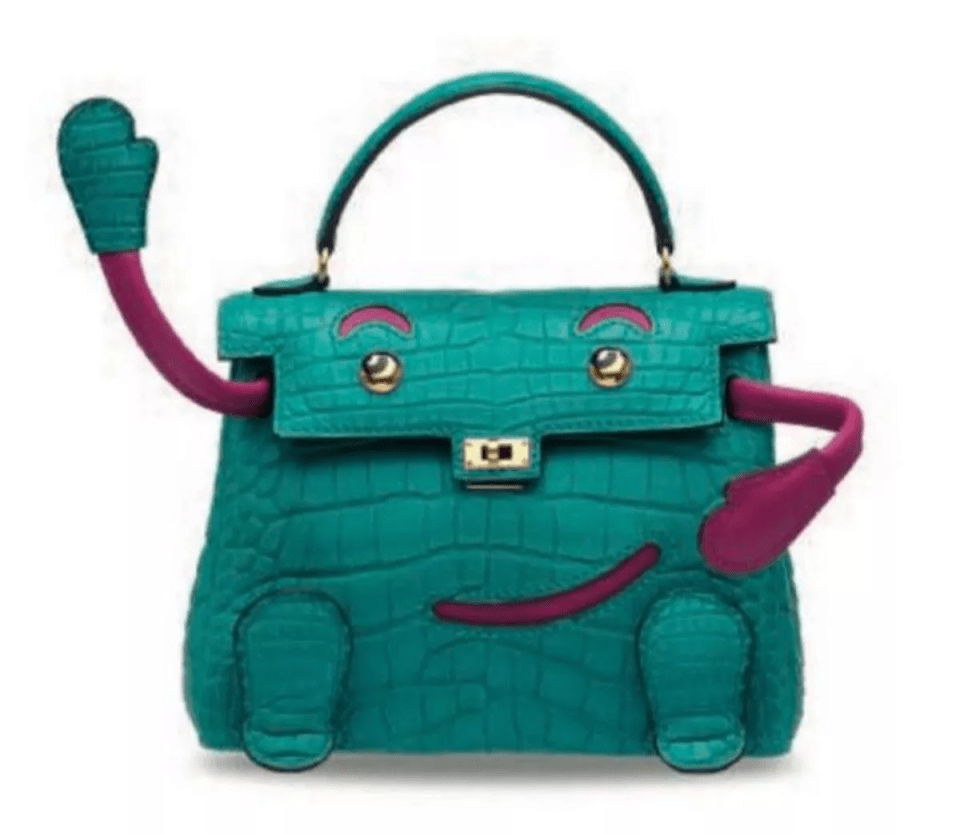 Teal crocodile Hermès handbag with added arms and legs, forming a cartoonish face.