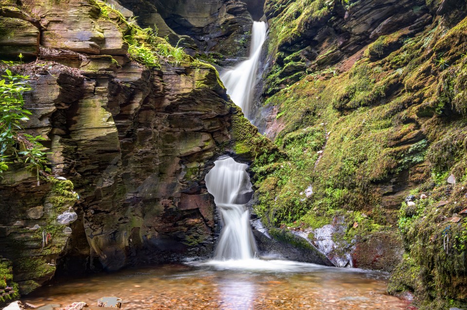 St Nectans Kieve waterfall cascading through a rock formation.