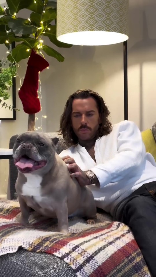 Pete Wicks petting his French bulldog.