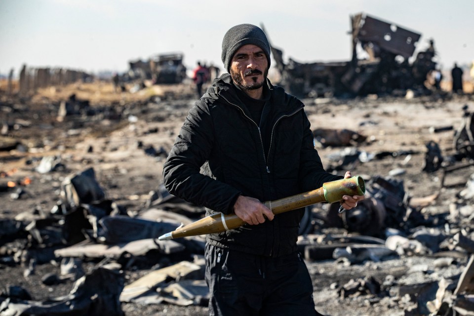 A Syrian carries unexploded ammunition picked up from the site of the previous evening’s Israeli airstrike