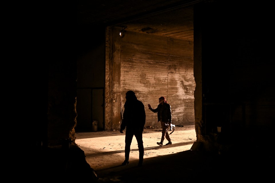 Syrian rebel fighters walk at the warehouse of a drug manufacturing facility