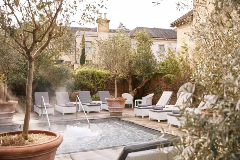 Outdoor heated pool and lounge chairs at a UK hotel.