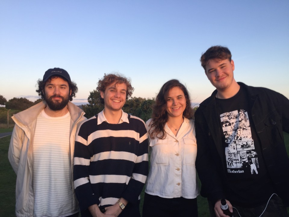 Four young adults posing outdoors.