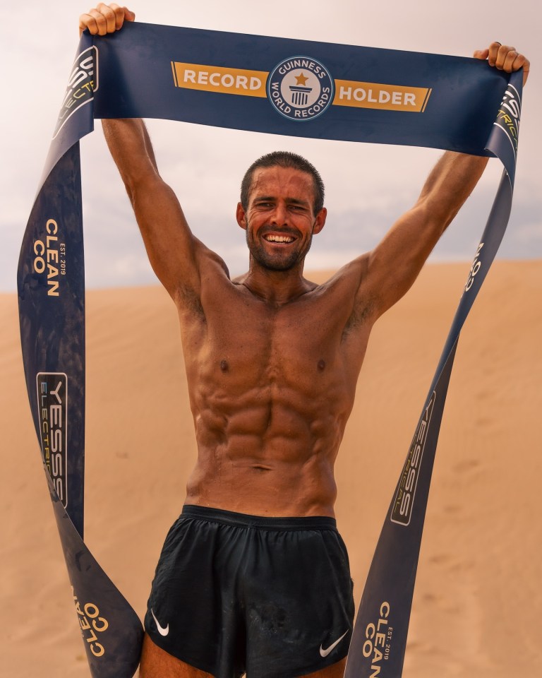 Spencer Matthews holding a Guinness World Records banner after completing 30 marathons in 30 days.