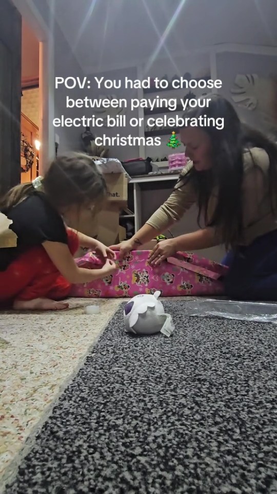 A mother and daughter opening a Christmas present; the mother had to choose between paying the electric bill or celebrating Christmas.