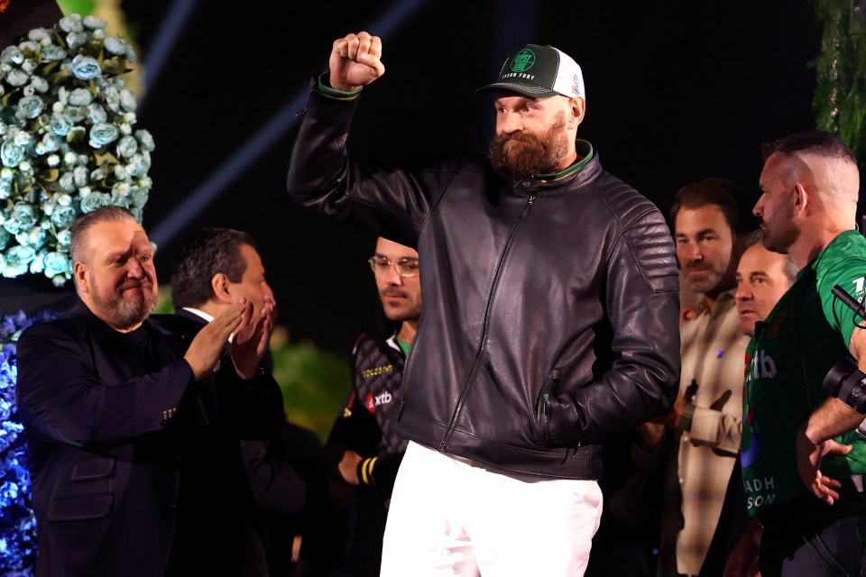 Tyson Fury at a weigh-in, raising his fist.