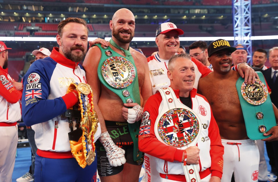 Fury celebrates his win over Dillian Whyte alongside Andy Lee, left, John Fury, middle, and SugarHill Steward, right