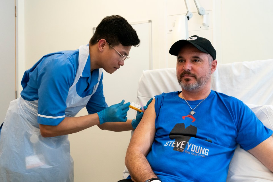 Nurse administering a cancer immunotherapy injection to a patient in a clinical trial.