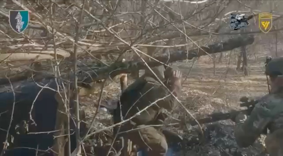 Russian soldiers are seen emerging from a bunker to surrender