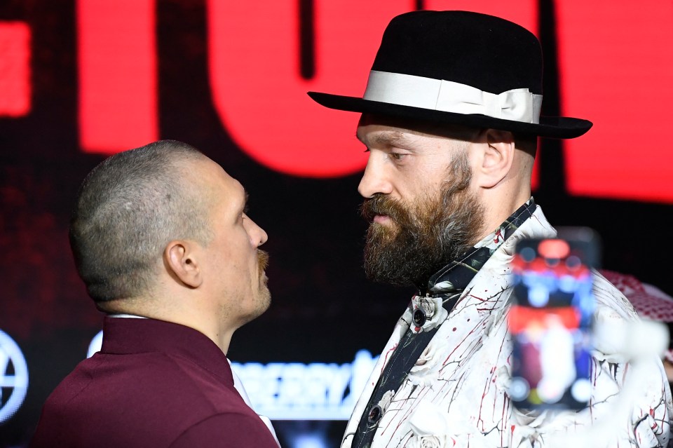 Tyson Fury and Oleksandr Usyk face off at a press conference.