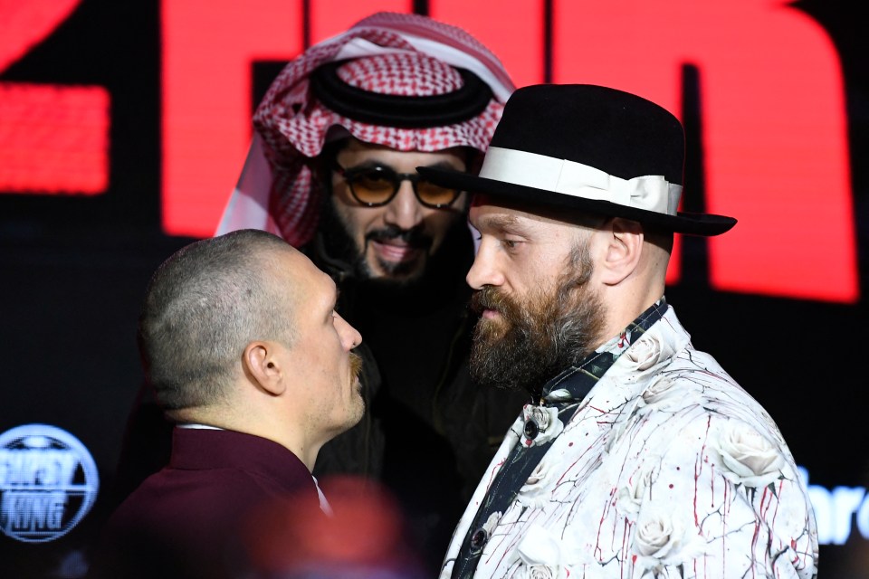 Tyson Fury and Oleksandr Usyk face off at a press conference.