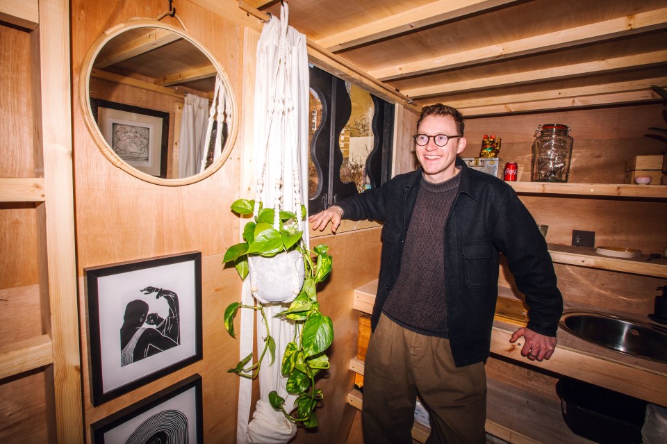 Artist Harrison Marshall standing in his converted skip studio.