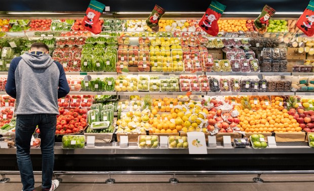 A man shops for produce in a supermarket.